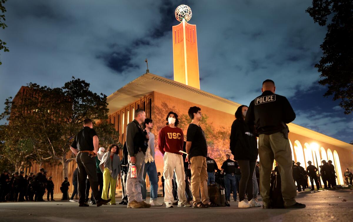 Protesters are detained on campus at night. 