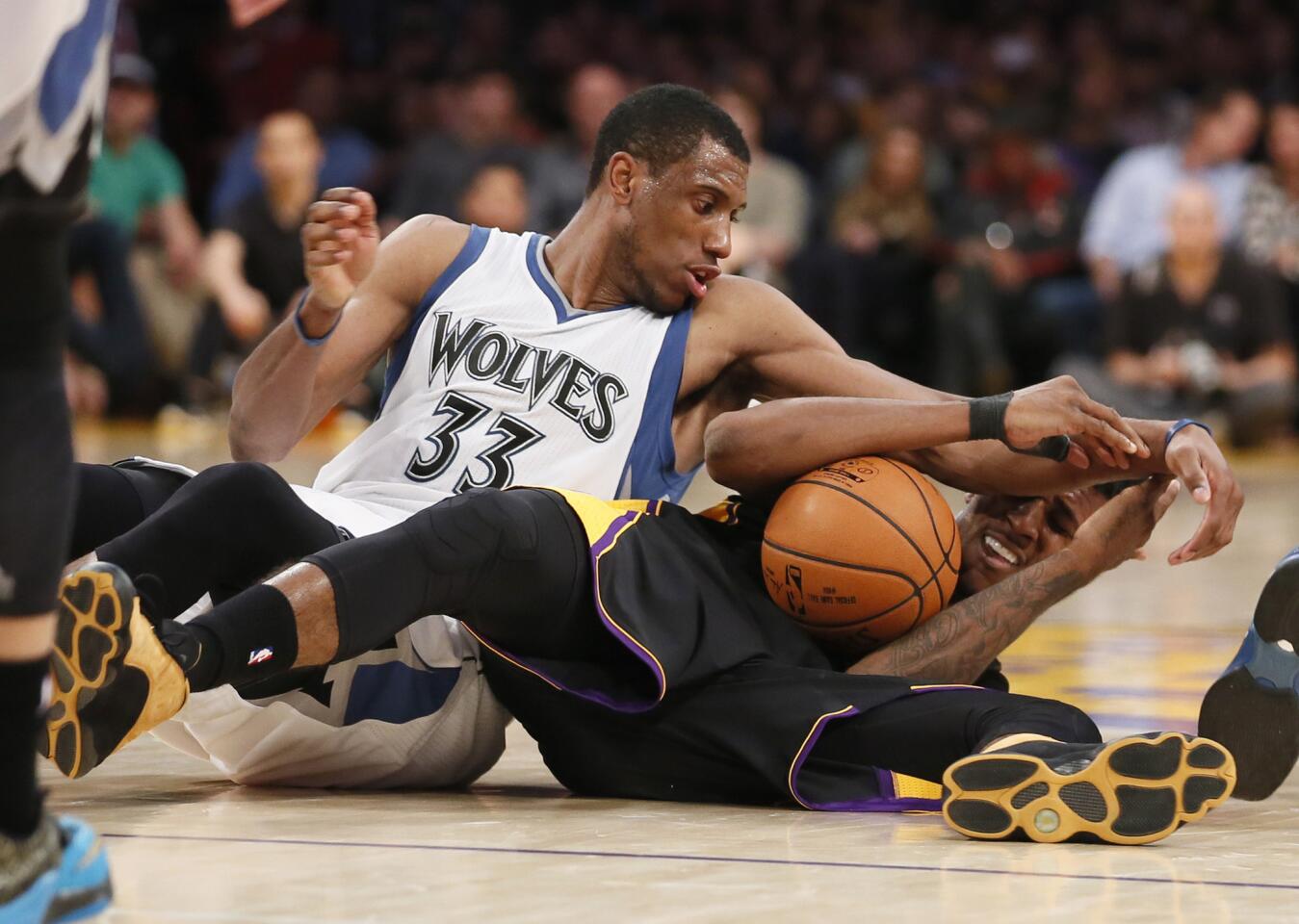 Lakers guard Nick Young and Timberwolves forward Thaddeus Young battle for a loose ball in the second half.