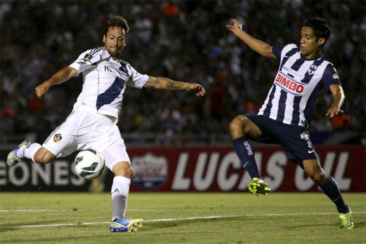 Galaxy's Todd Dunivant, left, prepares to kick a shot as Monterrey's Severo Meza attempts to block during a CONCACAF Champions League semi-final soccer match.