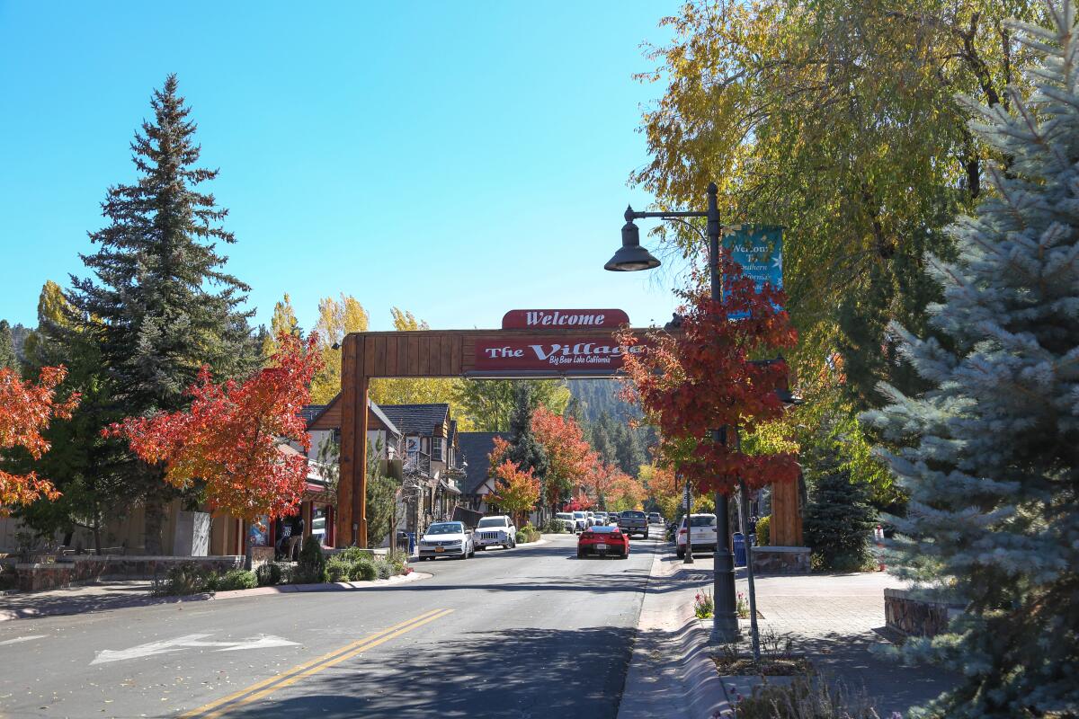 A sign over a mountain town road reads "The Village."