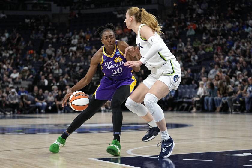 Los Angeles Sparks forward Nneka Ogwumike (30), left, works toward the basket against Minnesota Lynx forward Dorka Juhasz, right, during the first half of a WNBA basketball game Sunday, June 11, 2023, in Minneapolis. (AP Photo/Abbie Parr)
