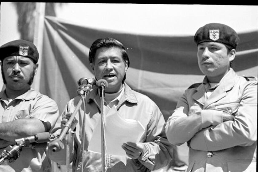 Cesar Chavez flanked by two Brown Berets, speaking at Los Angeles peace rally, 1971. For Chicano Moratorium series.