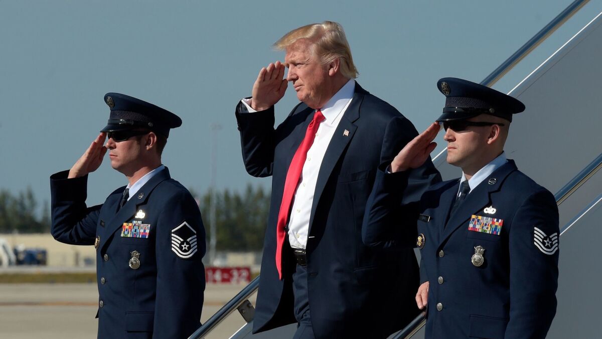 President Donald Trump salutes as he arrives a Palm Beach International Airport in Florida on Feb. 17.