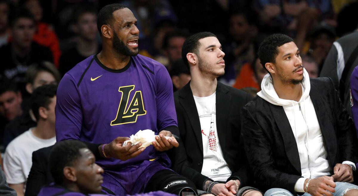 The Lakers' LeBron James, Lonzo Ball and Josh Hart watch teammates play against the Nets on March 22.