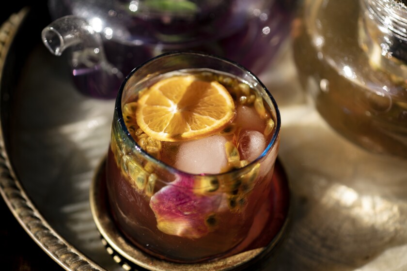 A Turkish tea made from herbs and fruit in a glass on a metal tray.