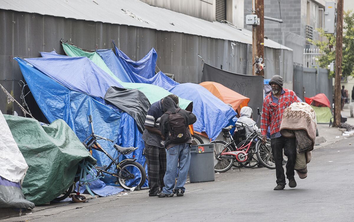 Homeless people set up tarps and tents in downtown Los Angeles' skid row.