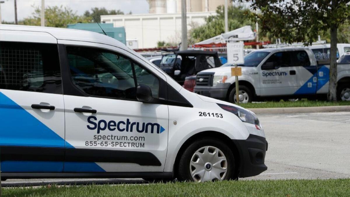 Spectrum trucks are parked at a customer center in Orlando, Fla., in September.
