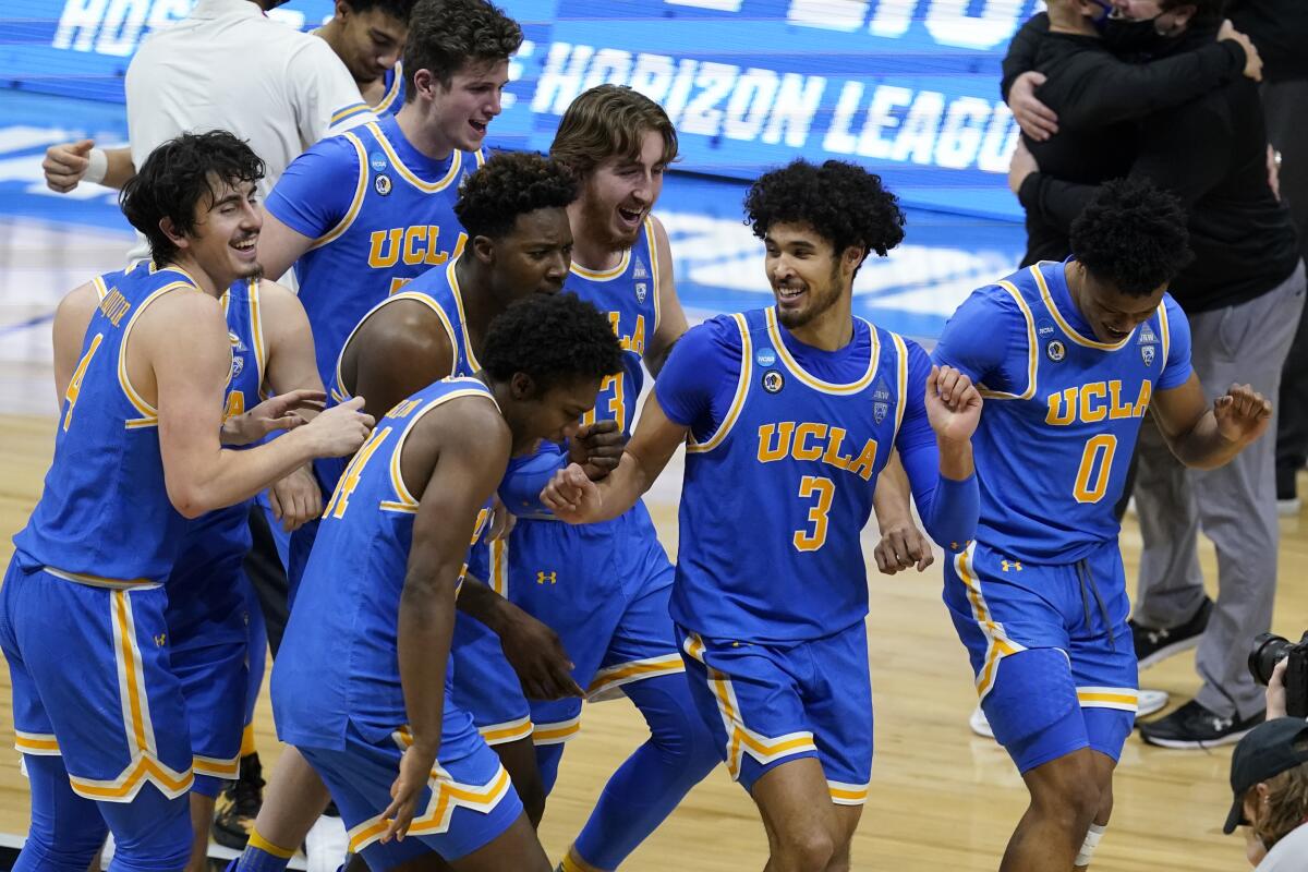 UCLA players celebrate after an Elite 8 game against Michigan in the NCAA men's college basketball tournament.