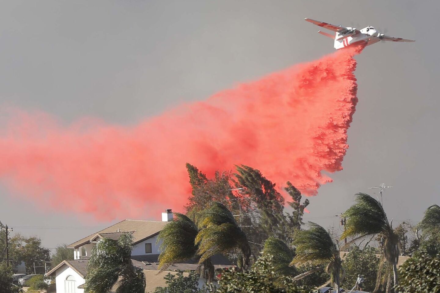 A CalFire tanker drops retardant on a portion of the Lilac Fire near Old Highway 395.