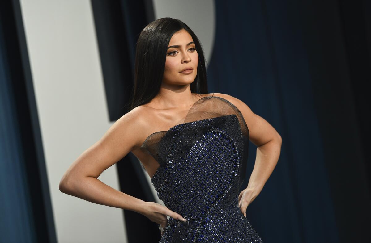 A woman puts her hands on her hips while posing at a red-carpet event