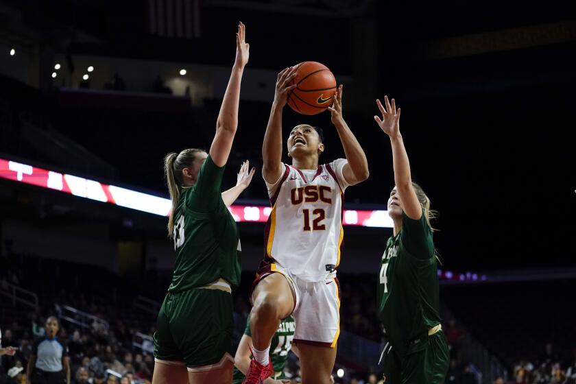 Southern California guard JuJu Watkins, center, shoots past Cal Poly forwards Amanda Olinger, left, and Sierra Lichtie during the second half of an NCAA college basketball game, Tuesday, Nov. 28, 2023, in Los Angeles. (AP Photo/Ryan Sun)