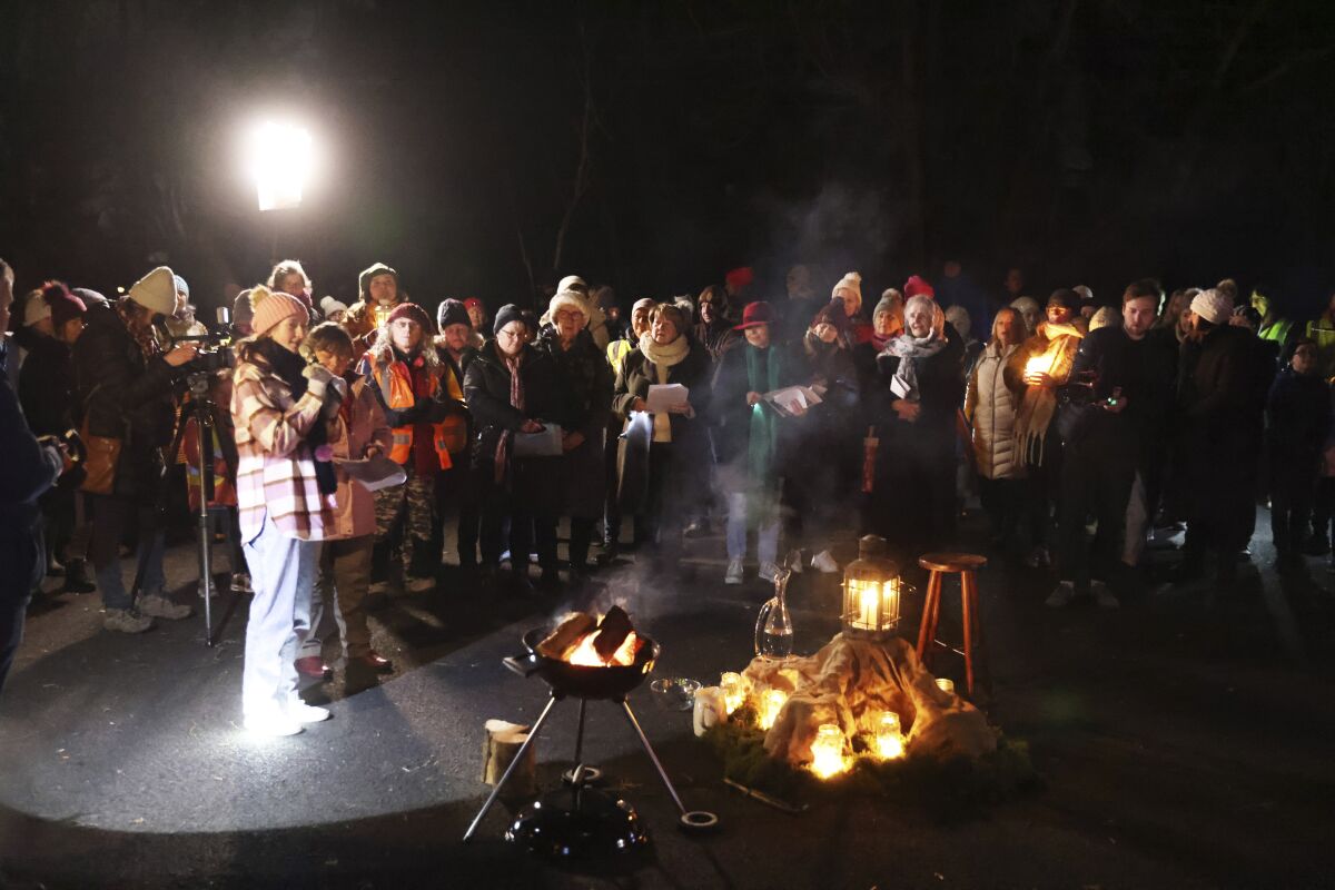 Un grupo de personas participa en un peregrinaje a la luz de las velas, el cual pasa junto a un antiguo pozo relacionado con Santa Brígida, el martes 31 de enero de 2023, en el Centro Solas Bhride en Kildare, Irlanda. (AP Foto/Peter Morrison)