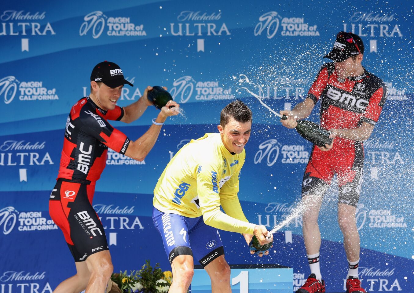 Amgen Tour of California winner Julian Alaphilippe (yellow jersey) celebrates on the podium with runner-up Rohan Dennis, left, and third-placer Brent Bookwalter on May 22 in Sacramento.