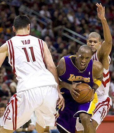 Lakers' Kobe Bryant drives between Houston Rockets' Yao Ming and Shane Battier during the third quarter Tuesday.