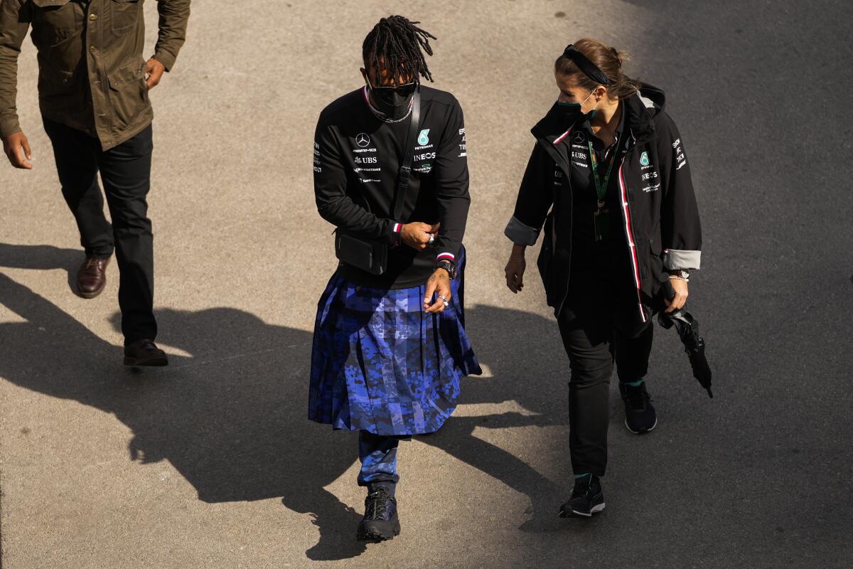 Mercedes driver Lewis Hamilton, left, of Britain walks at the paddock ahead of Sunday's Formula One Turkish Grand Prix at the Intercity Istanbul Park track, outside Istanbul, Turkey, Thursday, Oct. 7, 2021. (AP Photo/Francisco Seco)