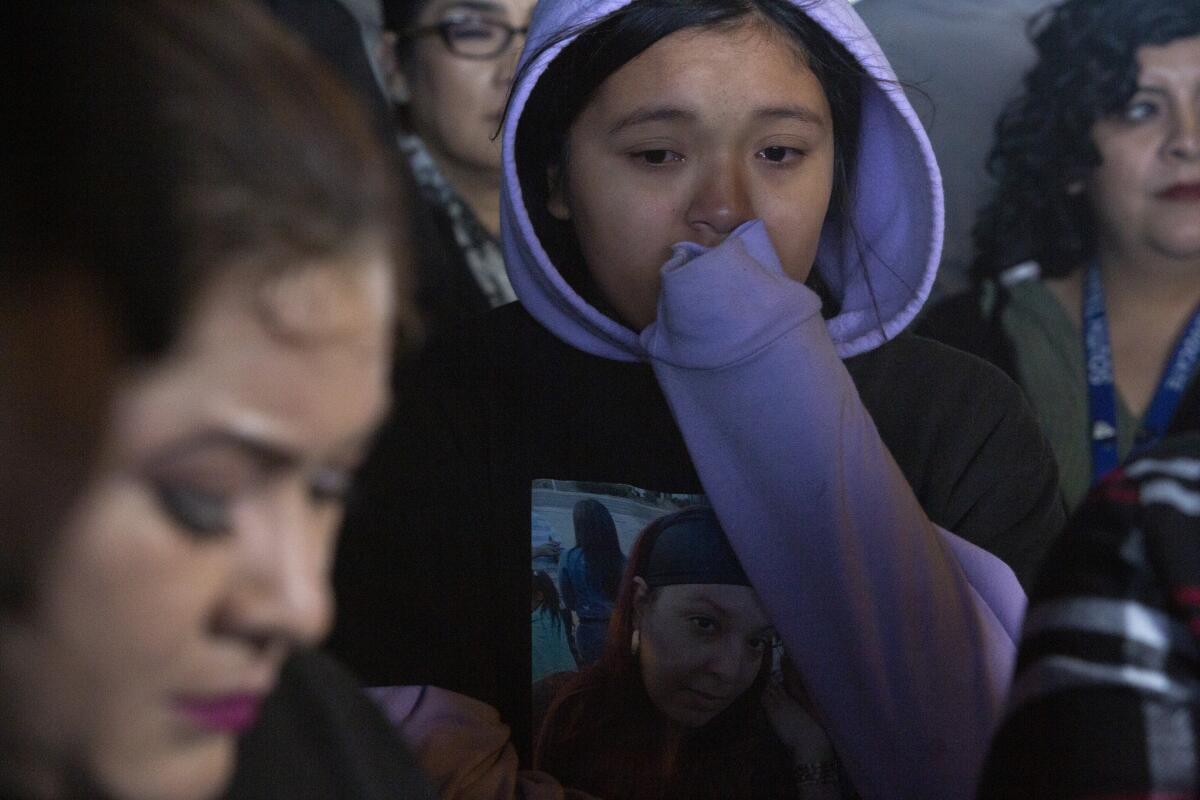Angela Rodriguez, 11, daughter of Kiesha Saravia, listens to her grandmother speak during a news conference