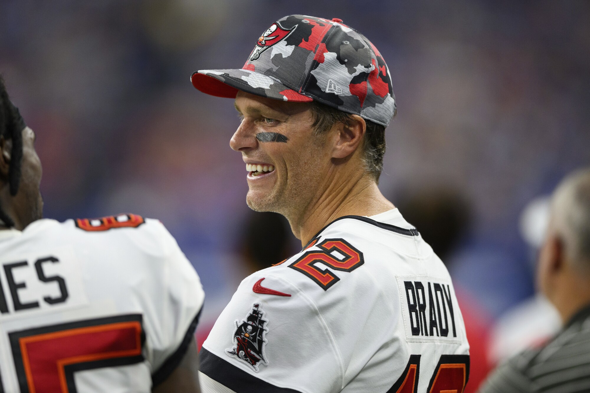 Tampa Bay Buccaneers quarterback Tom Brady laughs on the sideline.