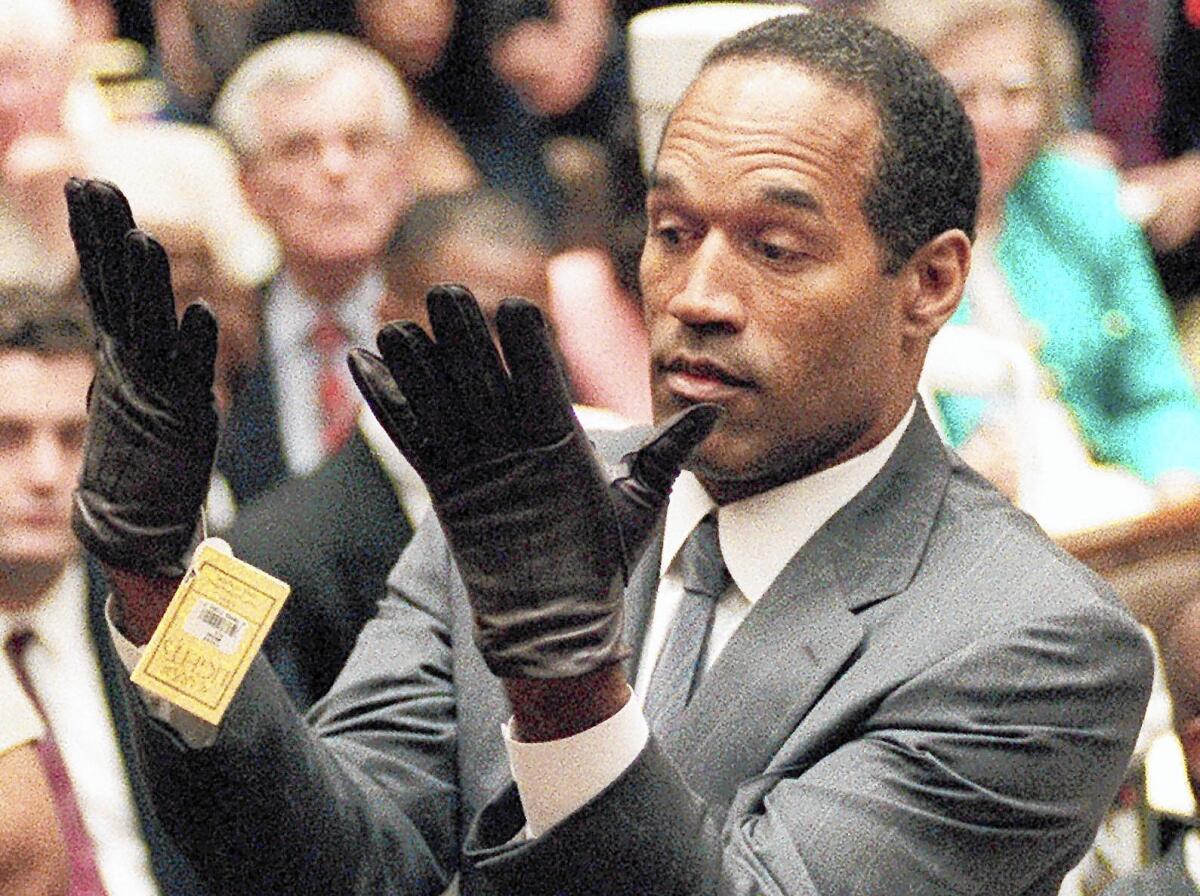 O.J. Simpson holds up gloved hands in front of the jury. (Associated Press)
