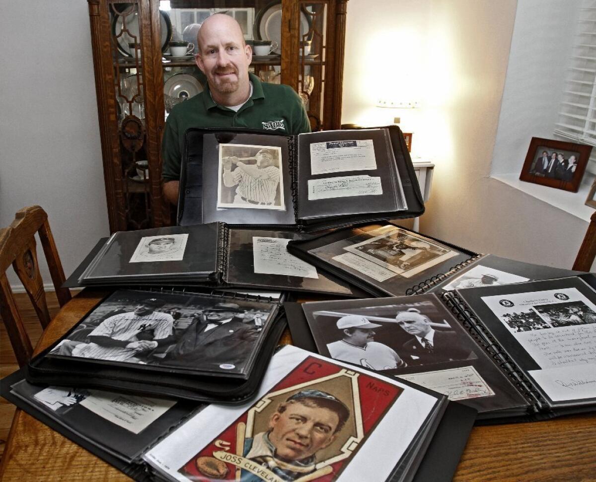 Crescenta Valley High teacher and former Falcons boys' basketball coach Jim Smiley shows off part of his extensive baseball collection.