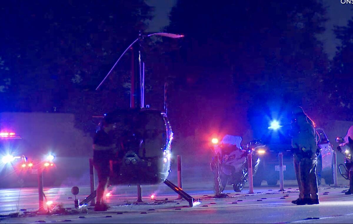 A helicopter sits on a closed freeway at night. 