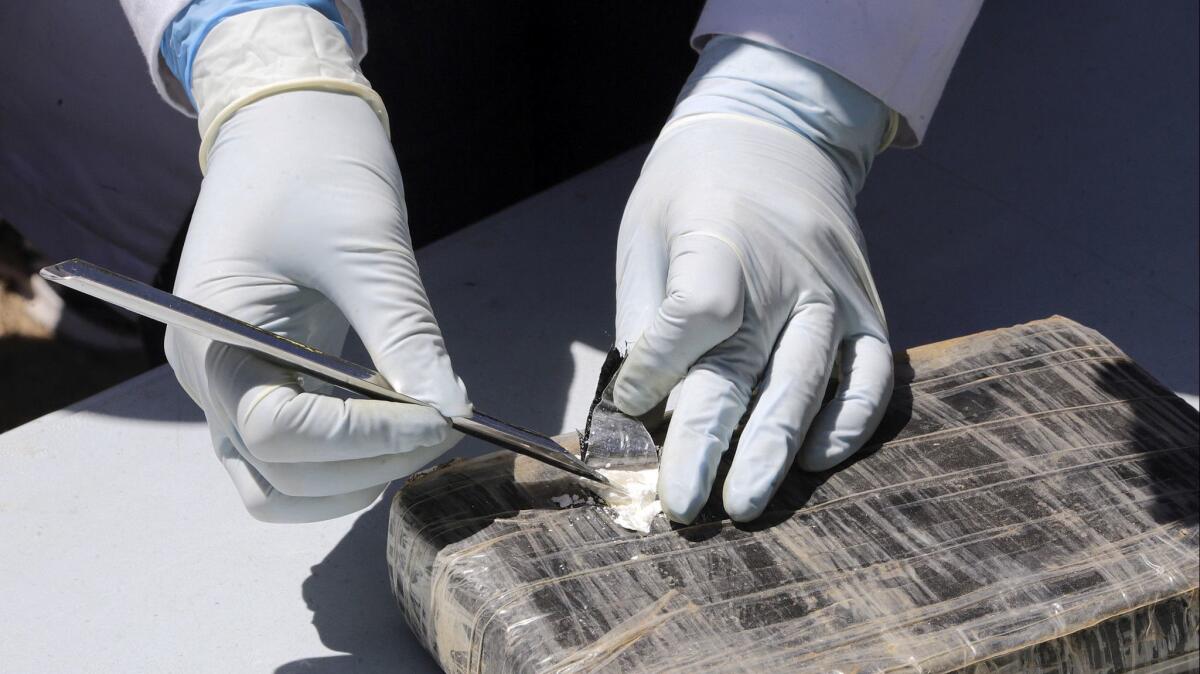 A technician cuts open a package of cocaine prior to its destruction by authorities on March 1.