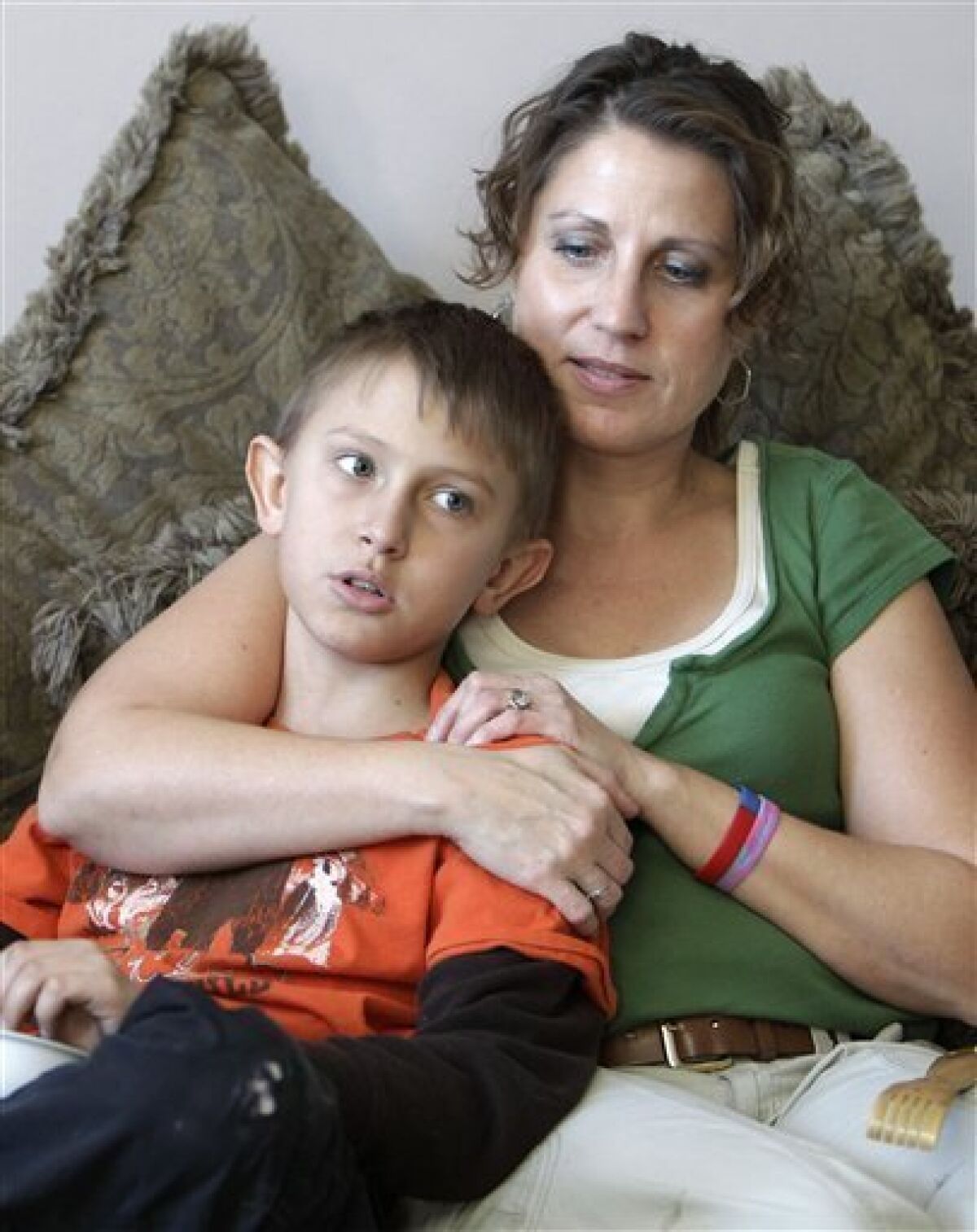 In this Dec. 14, 2010 photo, Donna Hisey holds her son Tanner in the family home near Clyde, Ohio. Tanner, 12, and his half-sister, Tyler Smith, are among the 36 kids who live within a few miles of this small farming town and have been struck by cancer in the last decade. (AP Photo/Mark Duncan)
