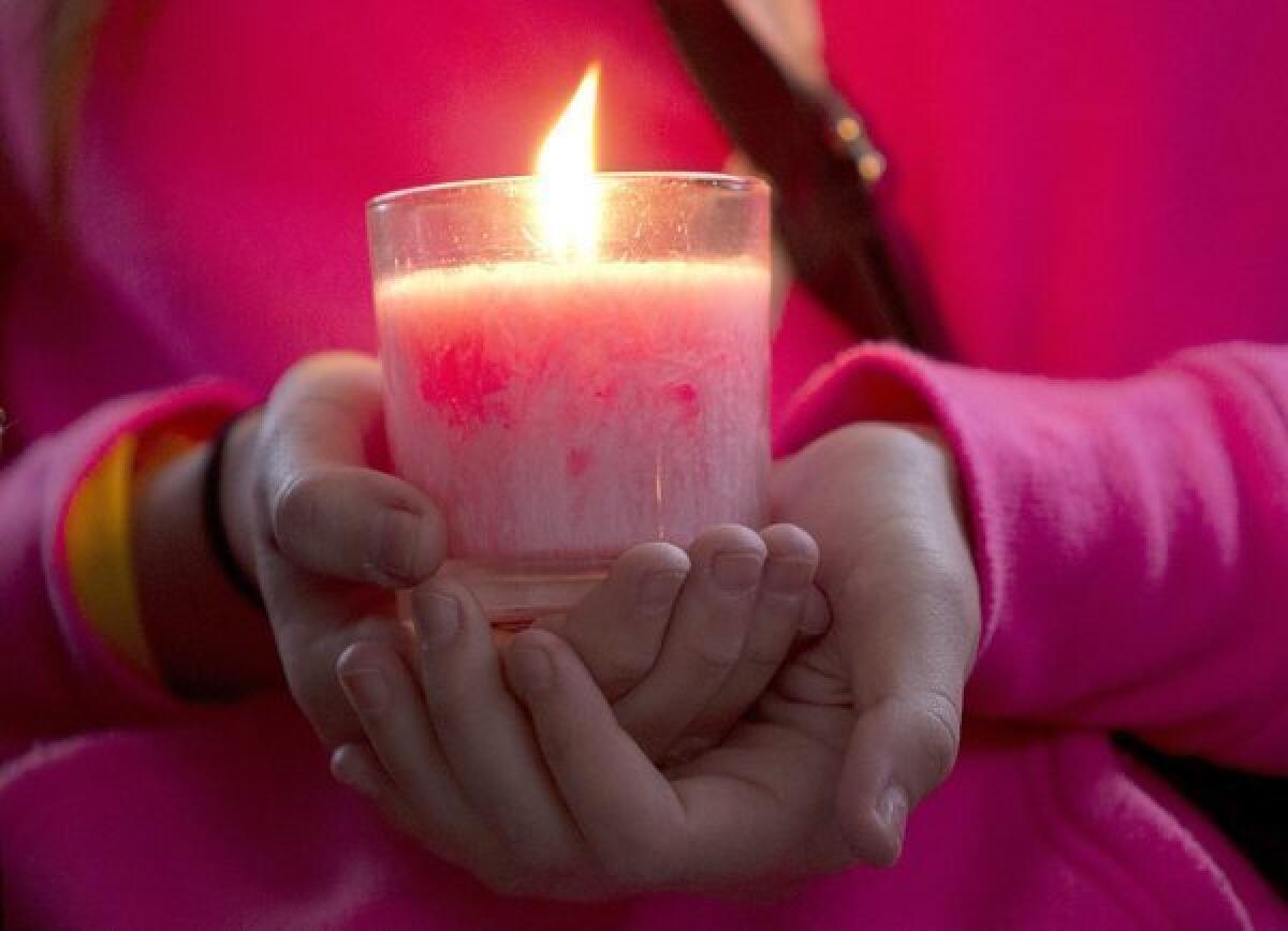A girl holds a pink candle during a memorial honoring teen Amanda Todd in Maple Ridge, Canada. Todd, who was bullied, took her own life on Oct. 10.