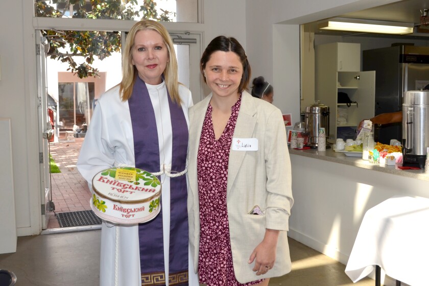 Rev. Canon Cindy Evans Voorhees accepts a Ukrainian cake from Costa Mesa resident Lidiia Zamaraieva from Odessa, Ukraine.
