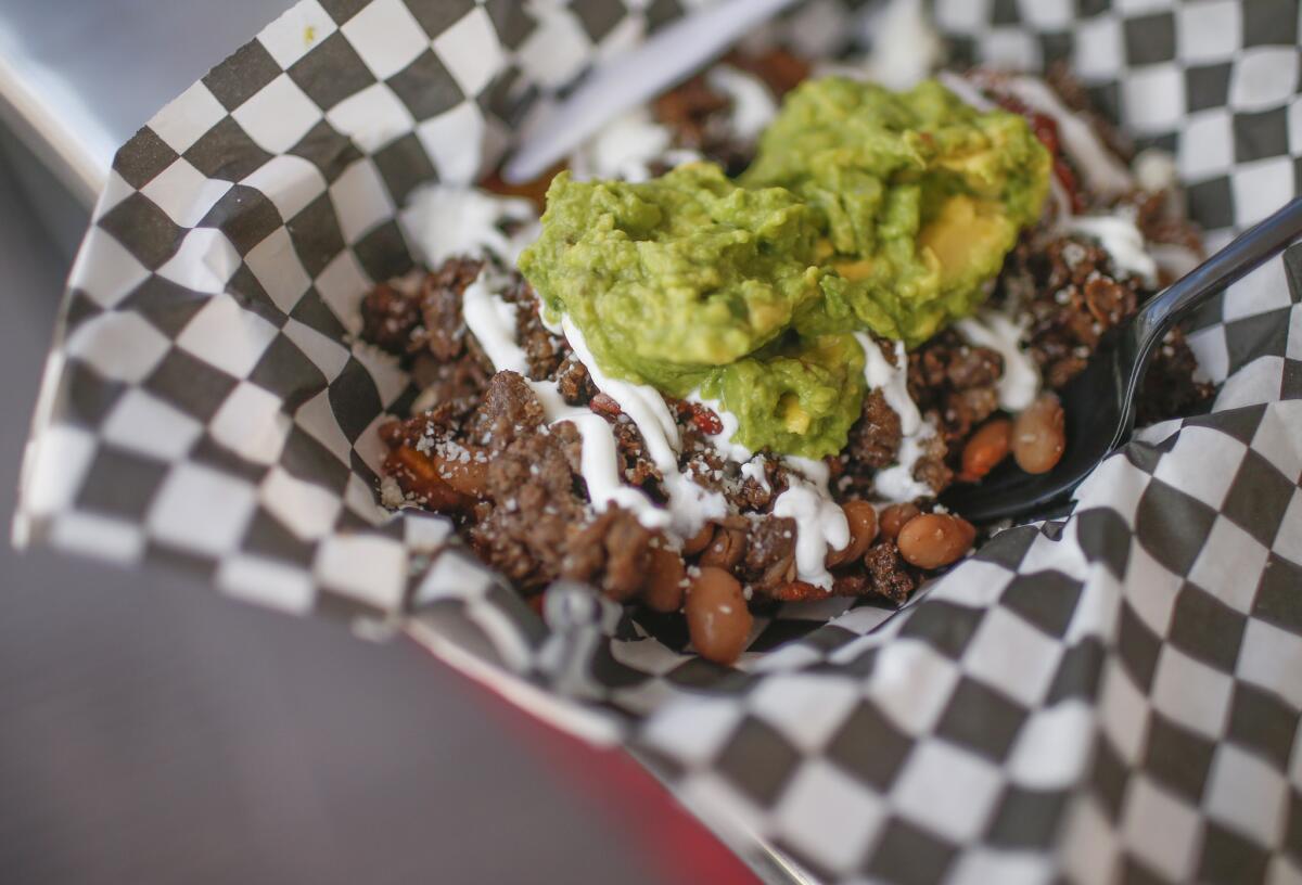 The Patacon, a fried plantain tostada topped with beans, farmer's cheese, fresh guacamole and angus beef, at Cali Fresh.
