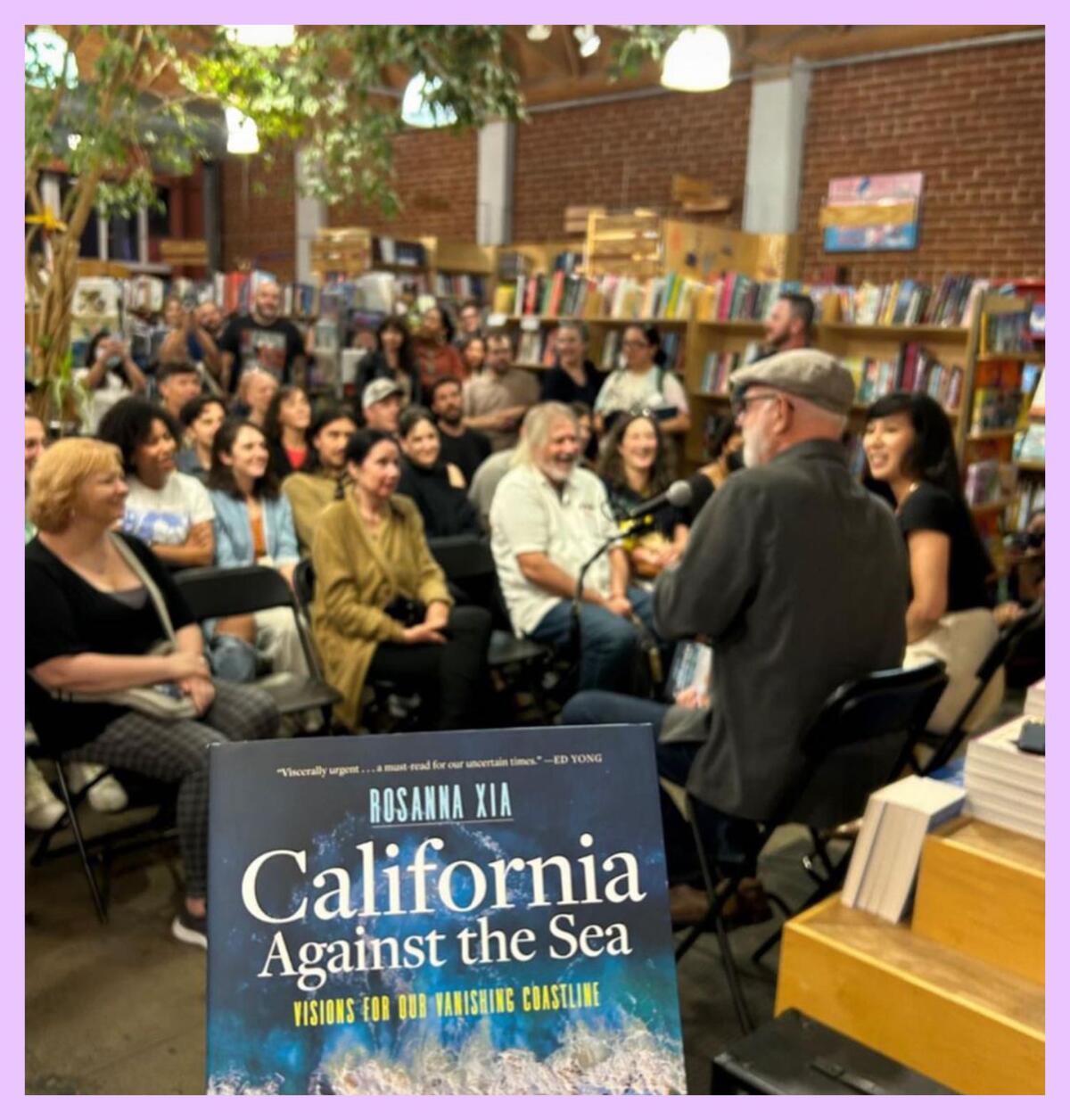A group of people listening to someone speak with a book cover for "California Against the Sea" in the foreground