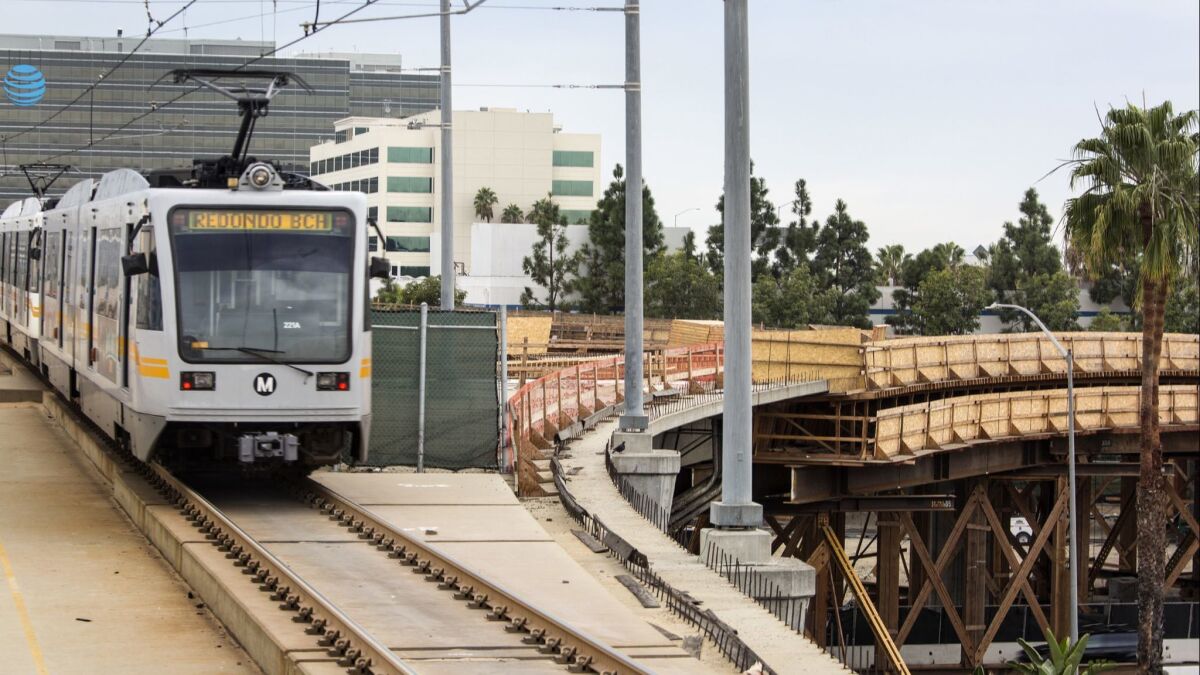 A Metro Green Line train leaves the Aviation/LAX station in El Segundo in 2016. The new Crenshaw Line will meet the Green Line near this stop, but transit officials are at odds over how to run trains along the junction shown to the right.