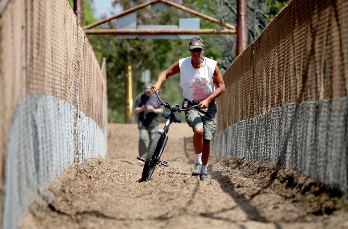 Burbank resident Doug Weiskopf walks his bike across the Mariposa Street bridge in Burbank in this file photo taken on May, 26, 2016.