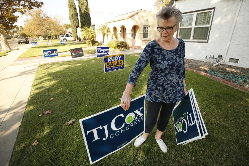 HANFORD, CA - OCTOBER 12: Cathy Jorgensen, chair of the Kings County Democratic Central Committee has a yard full of Democratic candidate signs in front of her Hanford California home and has a handful of TJ Cox signs ready for people who ask for them. It's a very close Congressional race in District 21 in the San Joaquin Valley. The position was held by four-time Republican David Valadao, who lost by fewer than 1,000 votes in 2018 to Democrat TJ Cox in a major surprise and they are facing off again. It is a mostly Democratic, rural, agricultural district that is 75% Latino, but Valadao is a local who had a lot of support. Congressional District 21 San Joaquin Valley on Monday, Oct. 12, 2020 in Hanford, CA. (Al Seib / Los Angeles Times