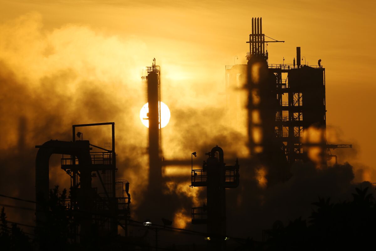 The Phillips 66 refinery looms over homes in the neighborhood of Wilmington of Los Angeles in March 2016. Oil companies, shipping interests and the trucking industry are among those asking California regulators to delay or relax air quality rules due to the COVID-19 pandemic.