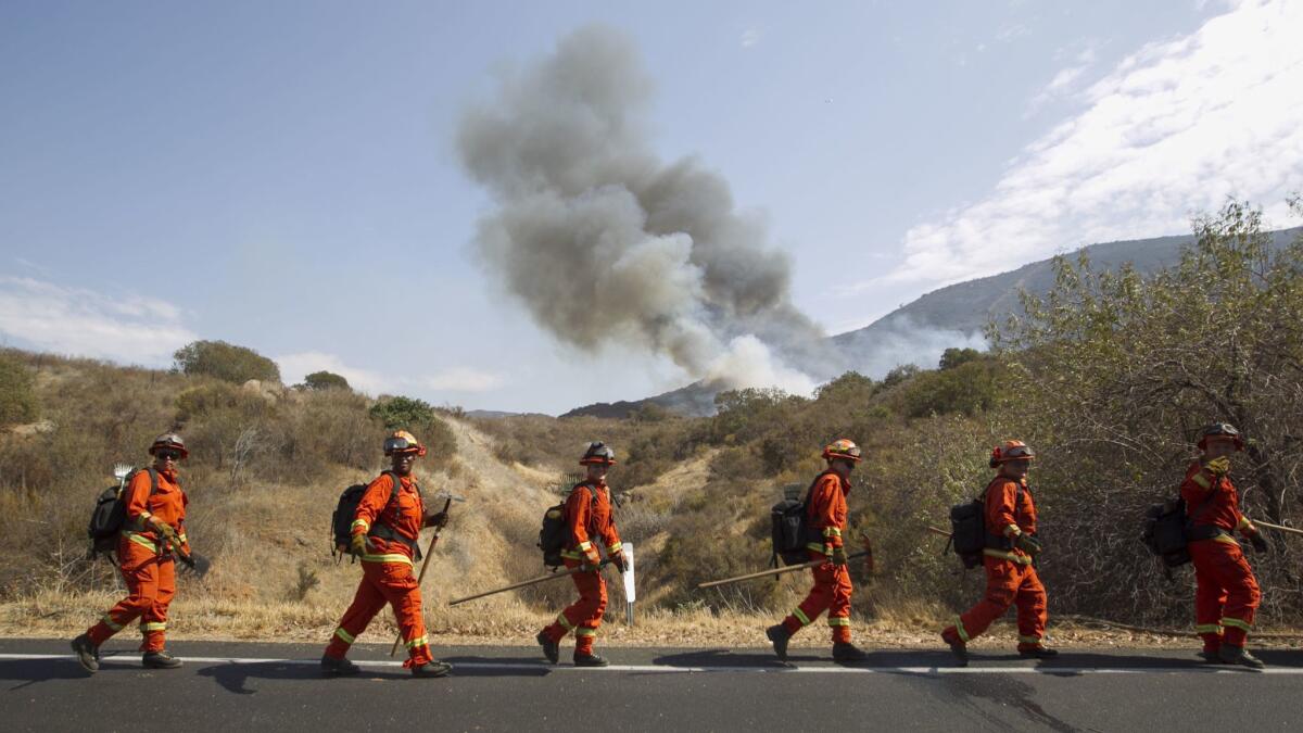 A crew of female firefighters from the California Department of Corrections' Rainbow Camp headed to the perimeter of the Rangeland Fire to start creating a fire break.