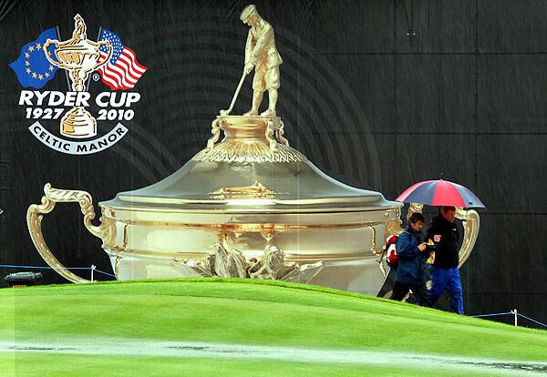 Spectators walk past the 18th green as rain falls and play is suspended during the Morning Fourball Matches during the 2010 Ryder Cup at the Celtic Manor Resort in Newport, Wales.