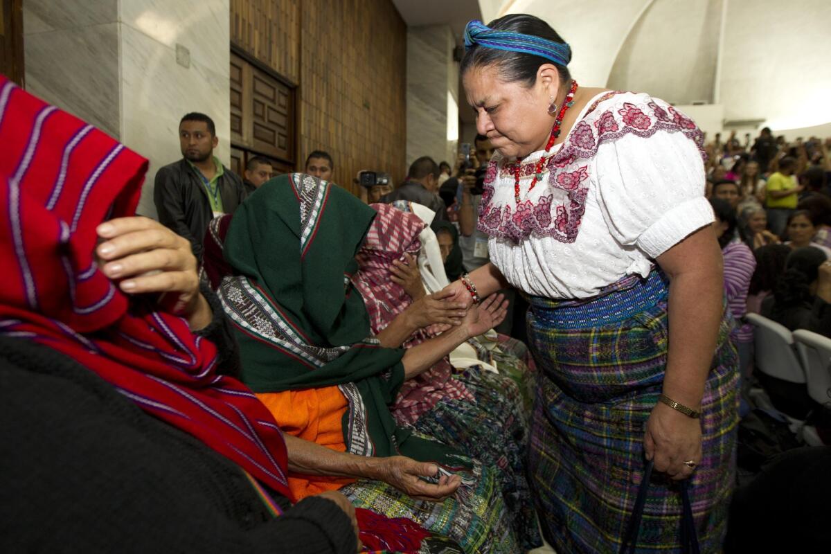 Rigoberta Menchú Tum, ganadora del premio Nobel de la Paz en 1992, estrecha la mano de víctimas de violencia sexual que se cubren el rostro para ocultar su identidad, momentos después de que un juez leyó un veredicto de culpabilidad para un exoficial militar y un excombatiente paramilitar por el abuso sexual de mujeres indígenas durante la guerra civil de Guatemala, dentro de un tribunal en Ciudad de Guatemala. El exoficial del ejército fue sentenciado a 120 años de cárcel y el otro a 240 años. Las víctimas dieron su testimonio sobre los abusos sexuales y psicológicos que sufrieron durante seis meses en 1982 y 1983 en una base militar. (Foto AP/Moisés Castillo)