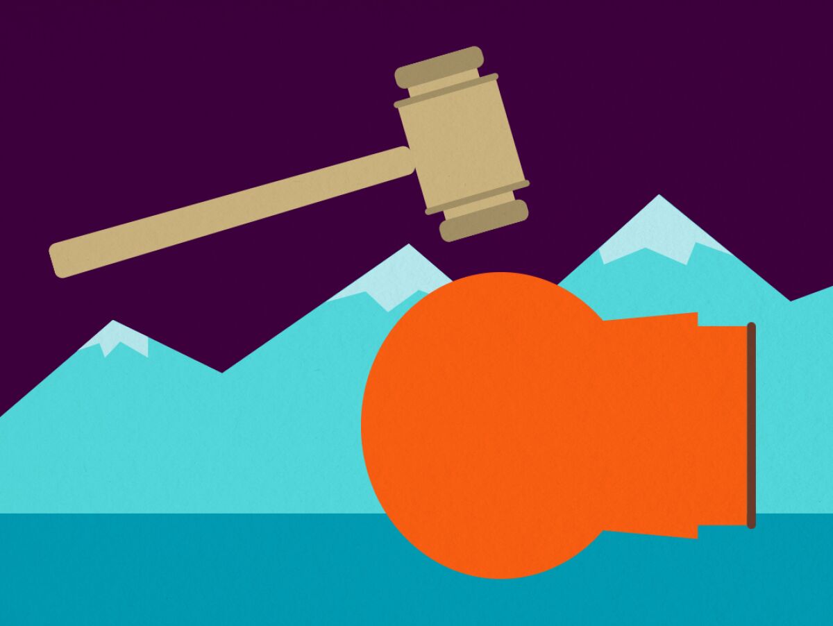 A gavel hovers over a child in an orange parka lying on his side.