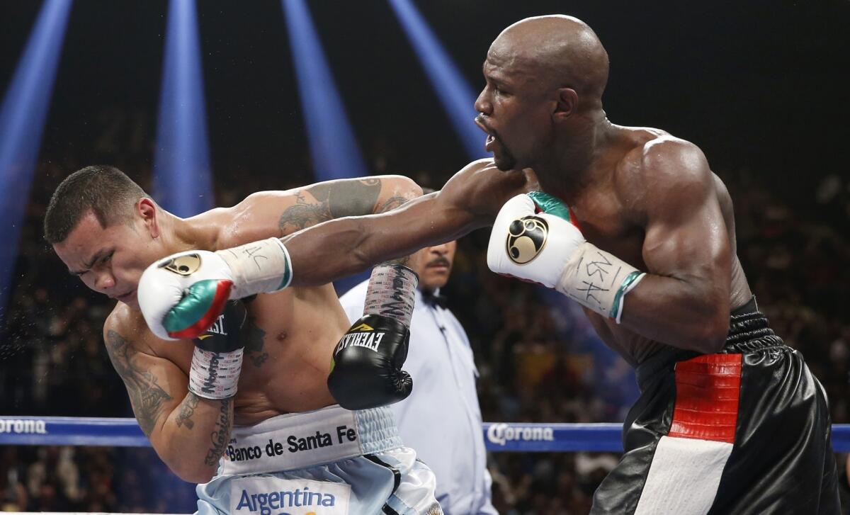 Floyd Mayweather Jr., right, connects on a right cross to the face of Marcos Maidana during their welterweight unification title fight in Las Vegas on Saturday night. Floyd Mayweather won the bout by majority decision.