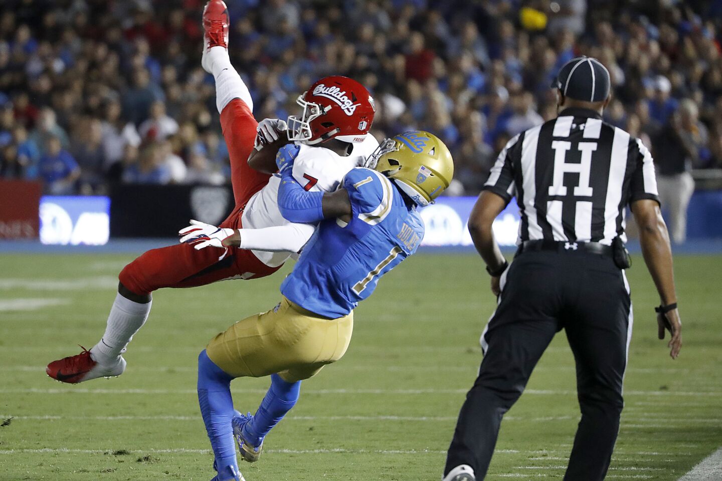 UCLA cornerback Darnay Holmes brings down Fresno State wide receiver Derrior Grim in the first quarter on Saturday.