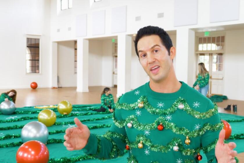Evan Mendelsohn, co-CEO/co-founder of Tipsy Elves, wears a smaller version of the ugly Christmas super sweater his firm made.