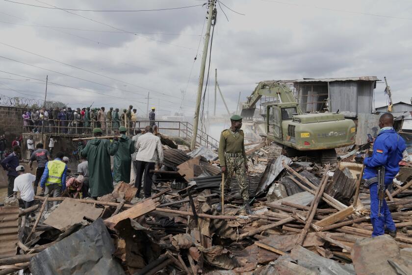 Una excavadora derriba varias casas en una zona ribereña del área de Mukuru en Nairobi, Kenia, el martes 7 de mayo de 2024. (AP Foto/Brian Inganga)