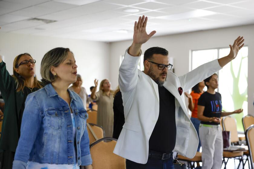 Juan Carlos Calderon Nava, an associate pastor at Centro de Esperanza Miami, an evangelical church with root in Venezuela, (R), during a service in Hallandale Beach, Florida, US, on Sunday, June 25, 2023. (Eva Marie Uzcategui / Los Angeles Times)