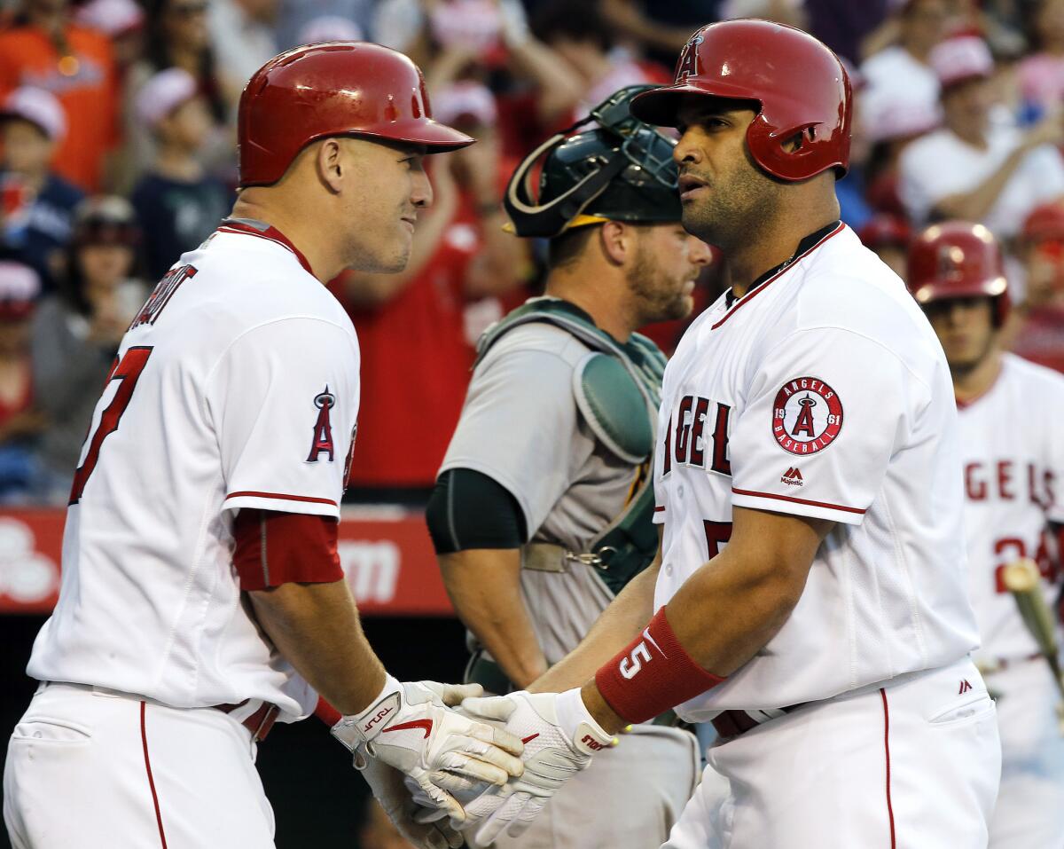 Angels outfielder Mike Trout, left, congratulates designated hitter Albert Pujols at home plate after Pujols hit home run No. 573 to tie Harmon Killebrew for 11th on the all-time list.