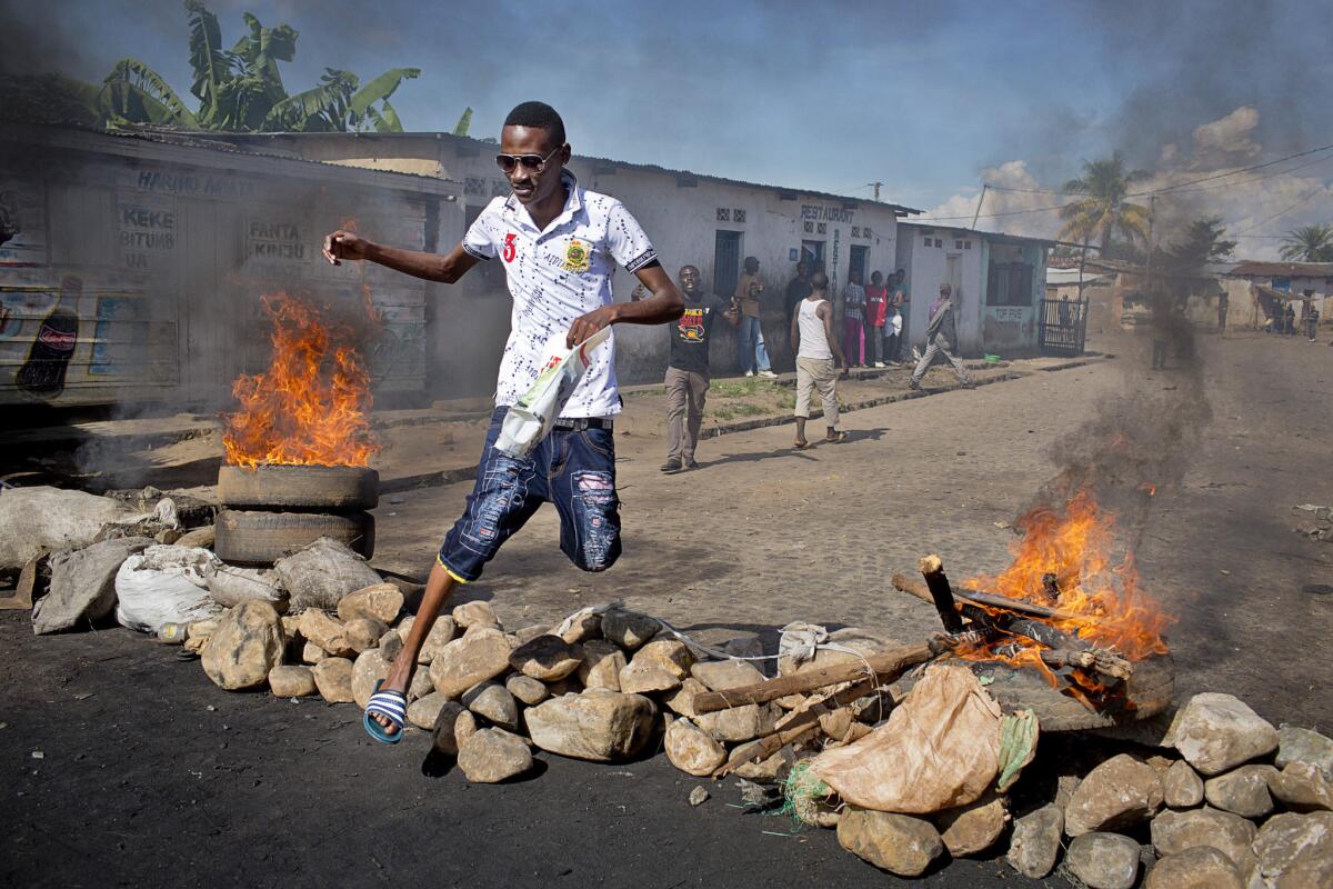 A man jumps over a barricade erected by residents during violence in Bujumbura, Burundi, on May 14.