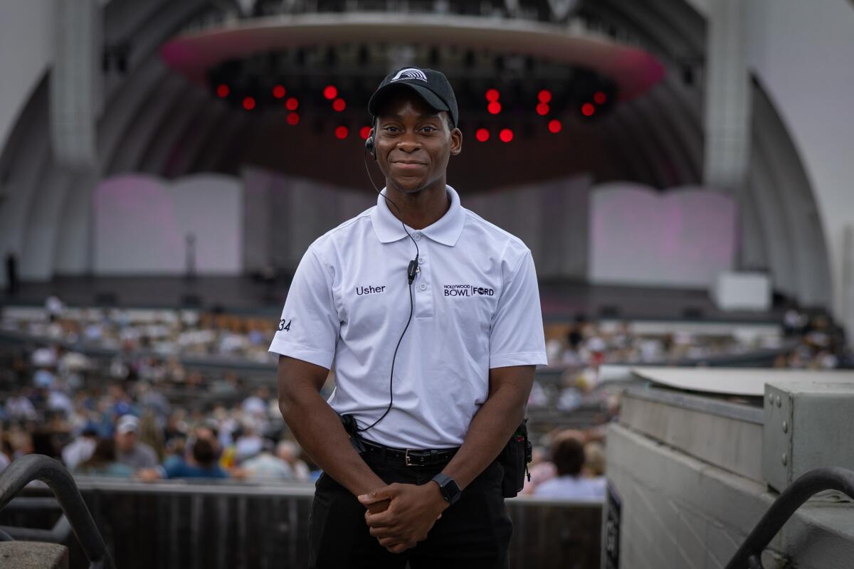Tyrone Huntley stands with a slight smile with the Hollywood Bowl stage behind him.