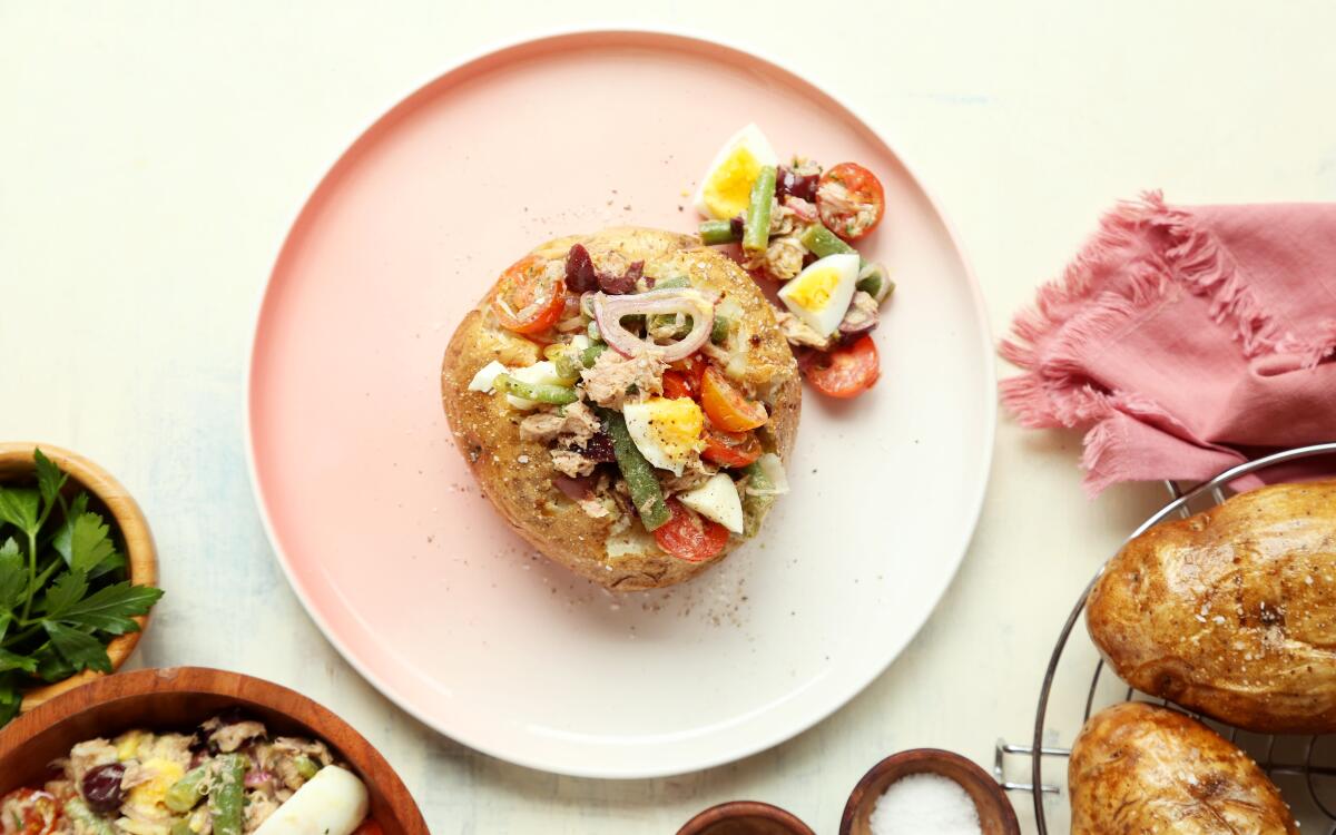 Ni?oise salad's traditional fingerling spuds transform into large baked potatoes topped with the classic salad's veggies.