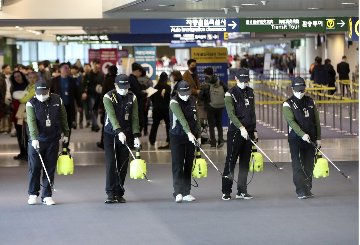 Workers spray antiseptic solution at Incheon International Airport in South Korea