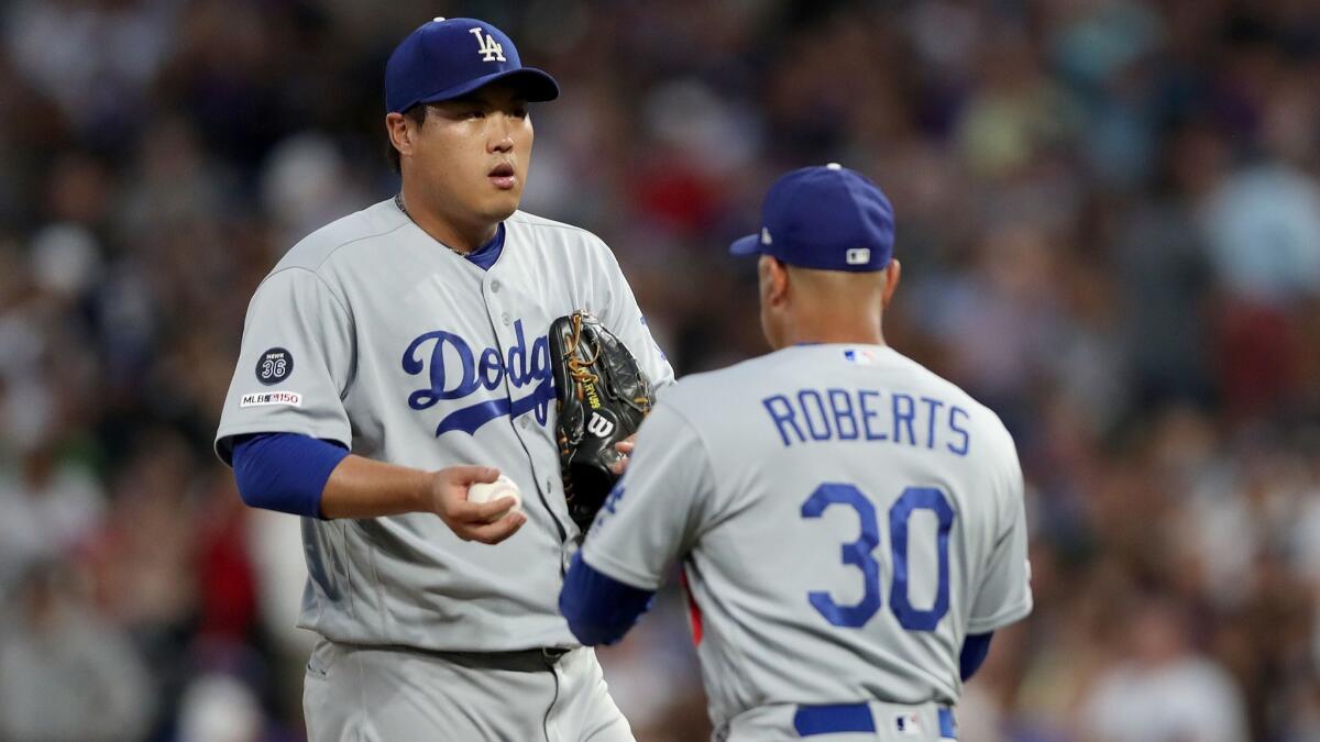 Los Angeles Dodgers starter Hyun-Jin Ryu hands the ball to manager Dave Roberts after being removed in the fifth inning of a 13-9 loss to the Colorado Rockies on June 28. Ryu saw his ERA climb from 1.27 to 1.83, still the best in the majors.