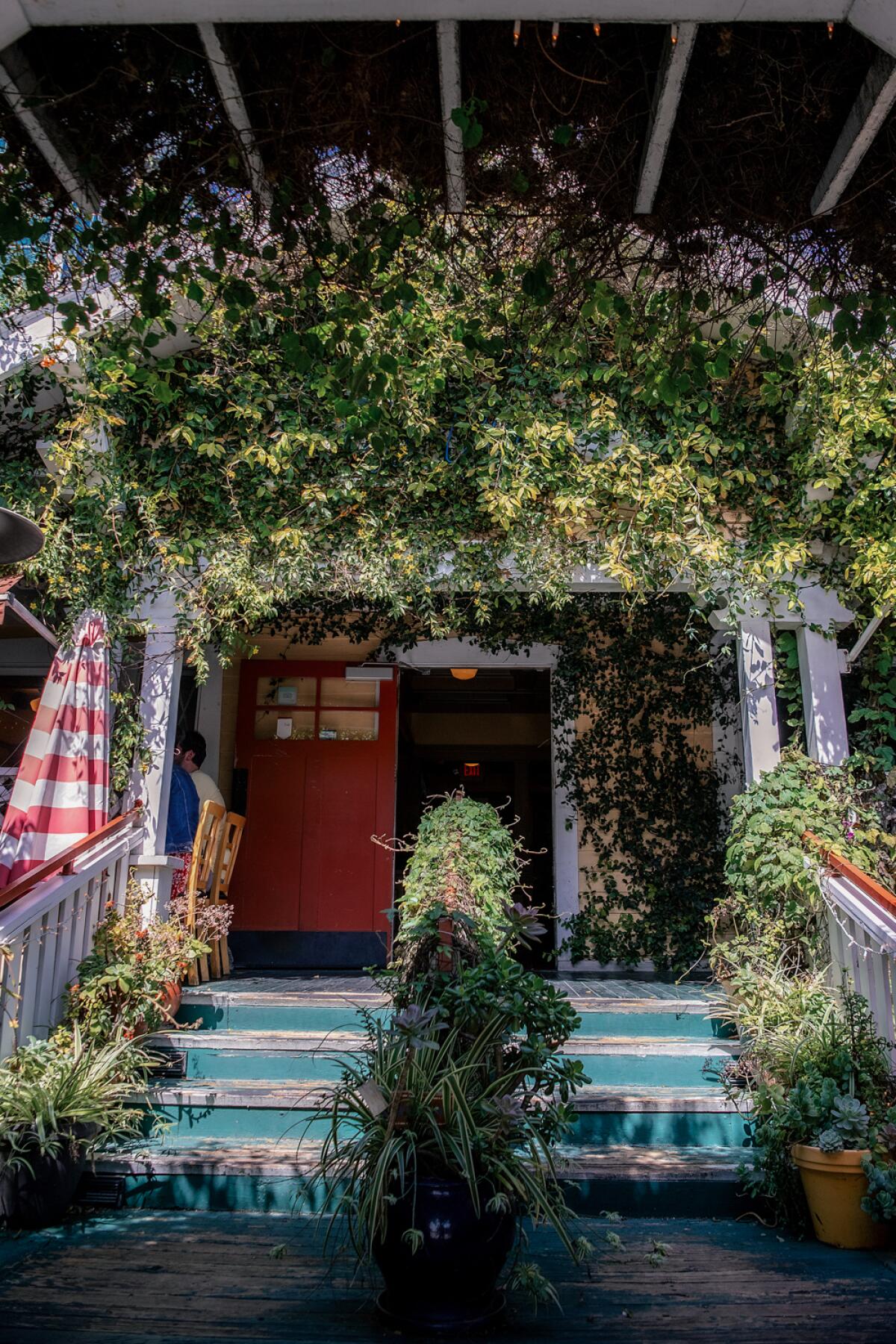 Steps lead to a porch where people dine.